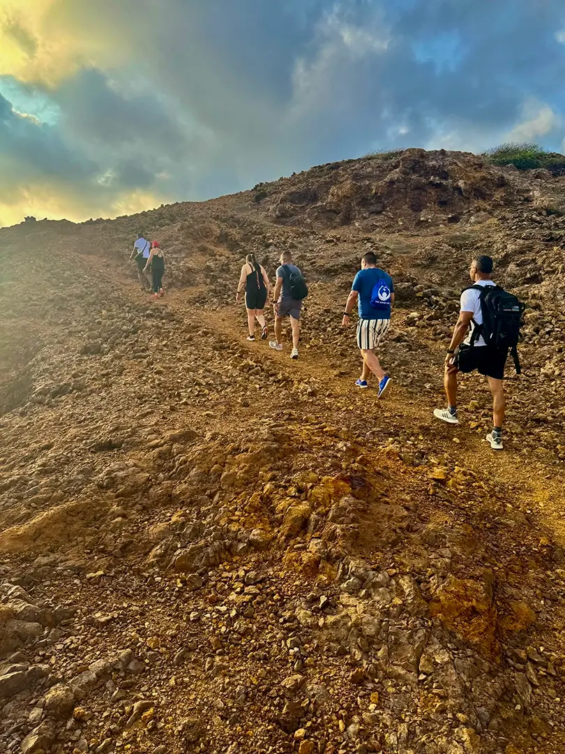 Group hiking up the rugged Sero Colorado trail at sunrise