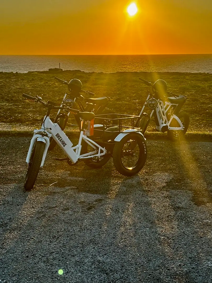 E-bikes parked at sunrise over the sea