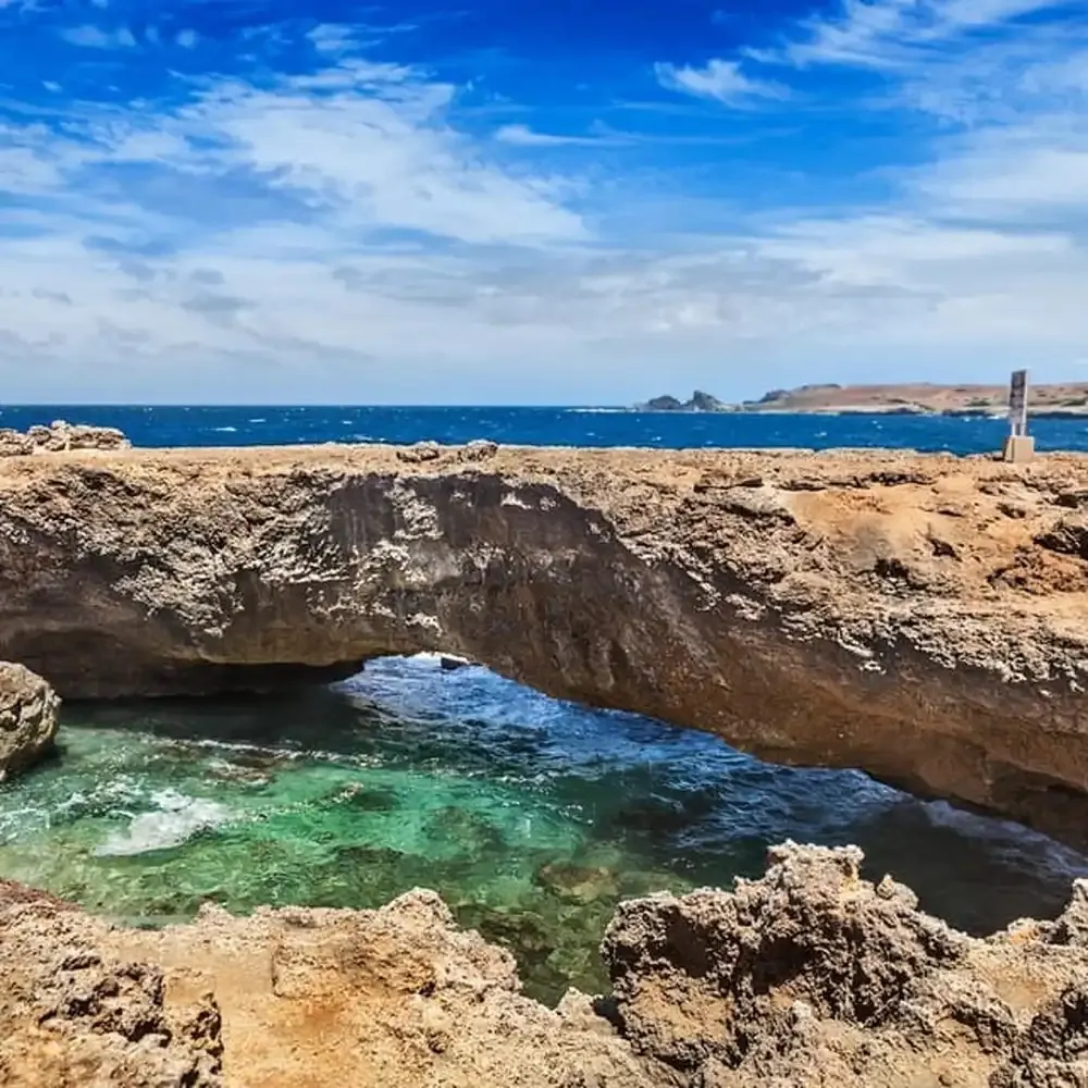 Natural rock bridge over a turquoise tidal pool