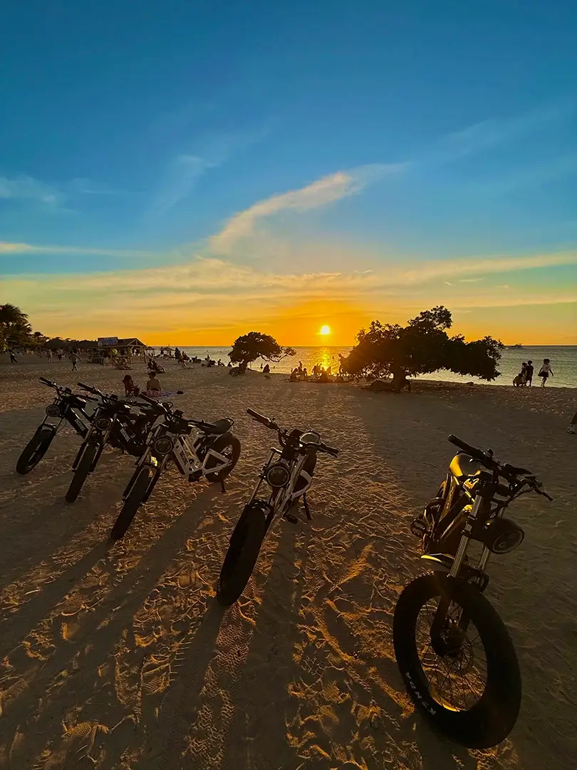 E-bikes lined up on the beach at sunset