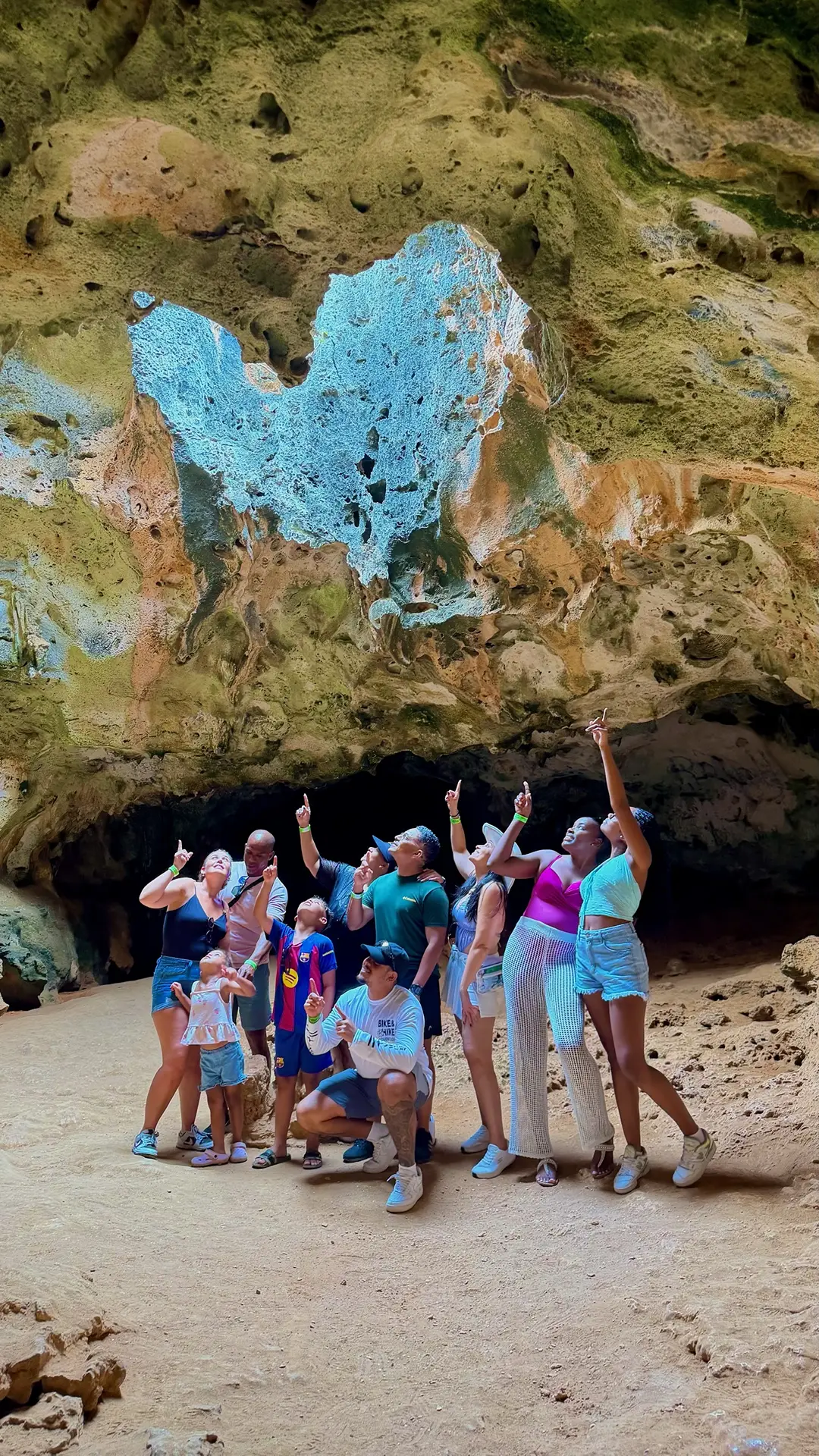 Tour group pointing up at the cave ceiling opening in Quadirikiri Cave