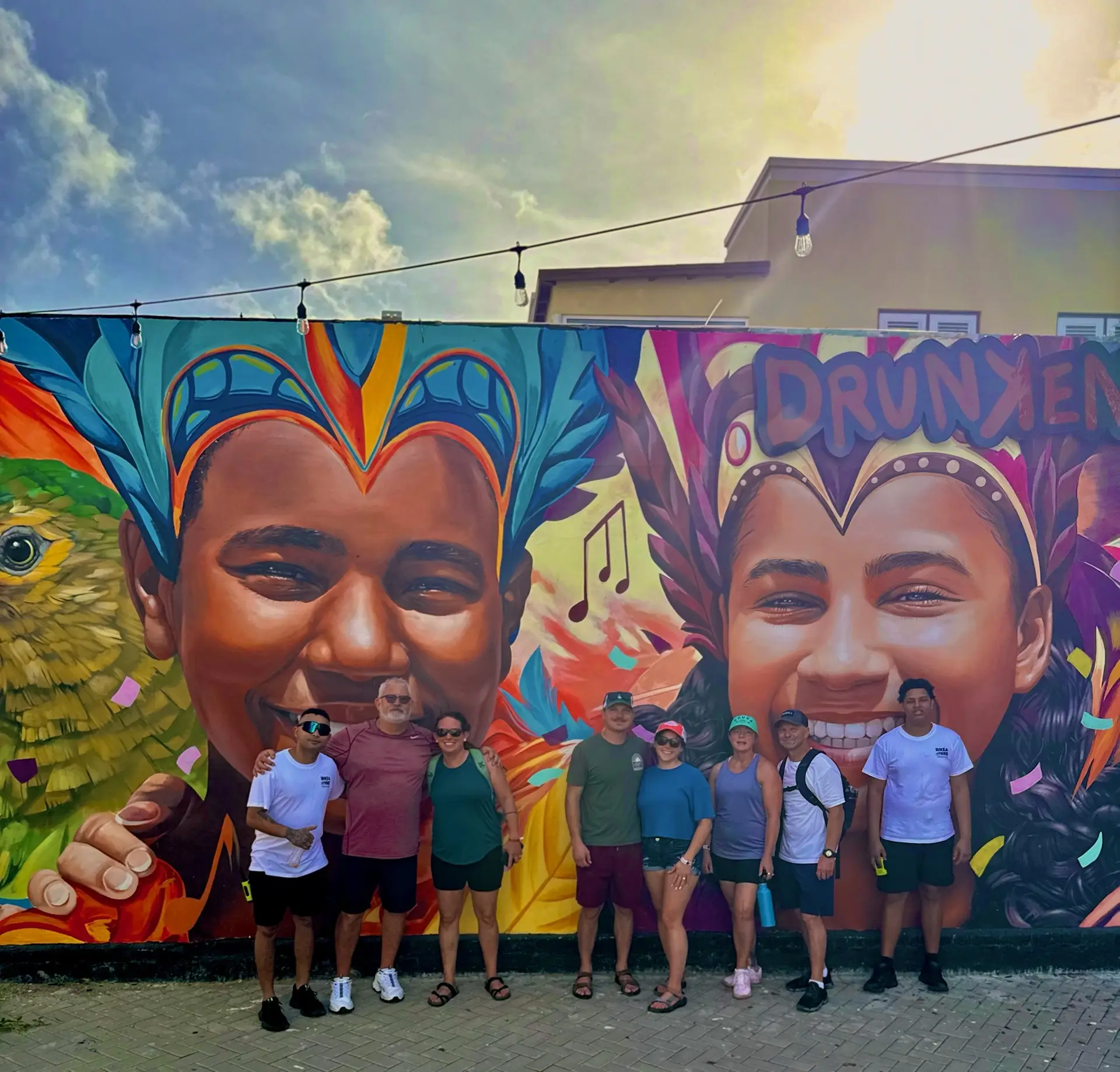 Group in front of vibrant carnival mural in San Nicolas