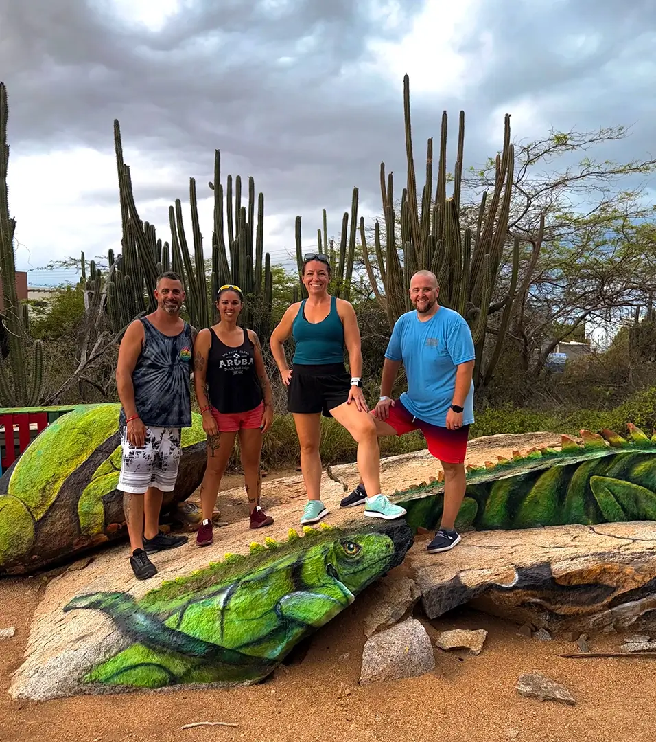 Group posing with the colorful iguana rock art