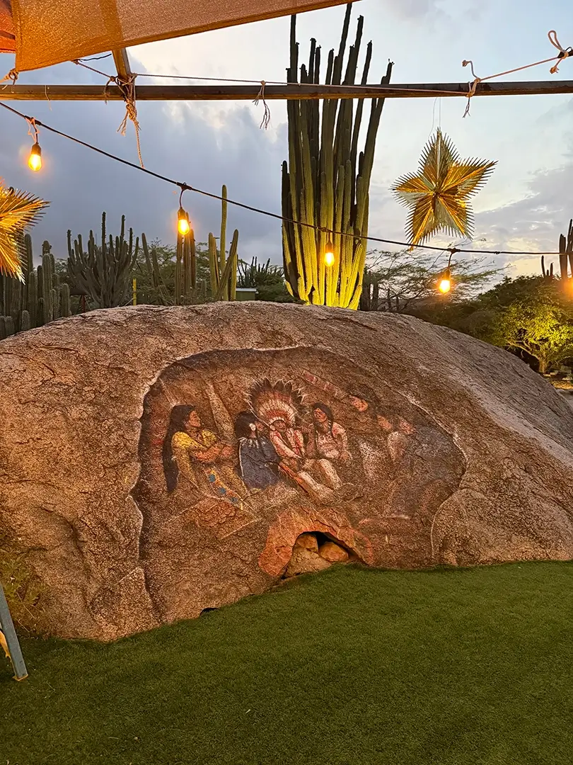 Aruban rock painting glowing under string lights at the Paradera shack